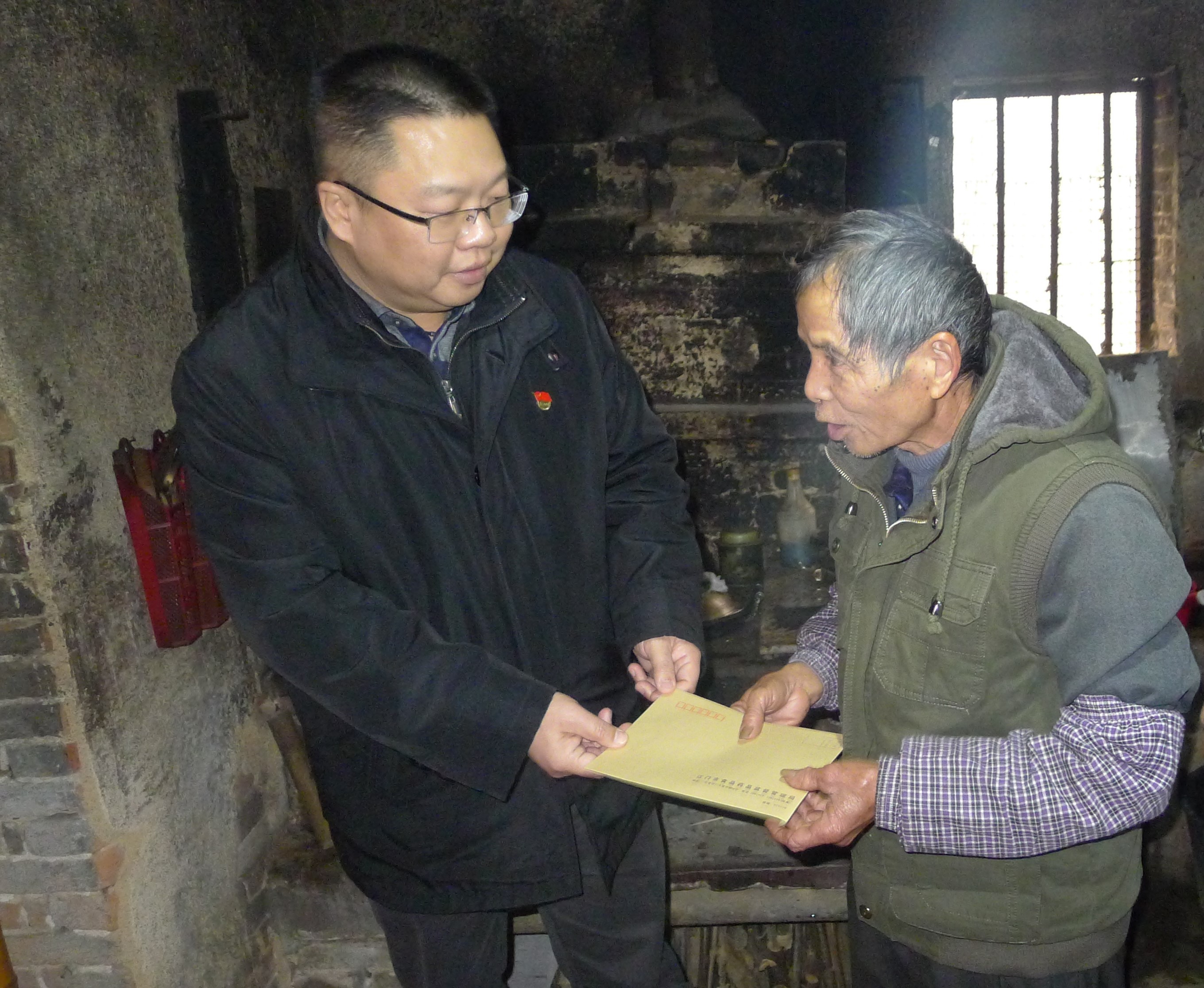 圖為：江門市食品藥品監(jiān)督管理局黨組成員、紀(jì)檢組長蔣業(yè)洲向黃村村委會吳達文送上春節(jié)慰問.jpg